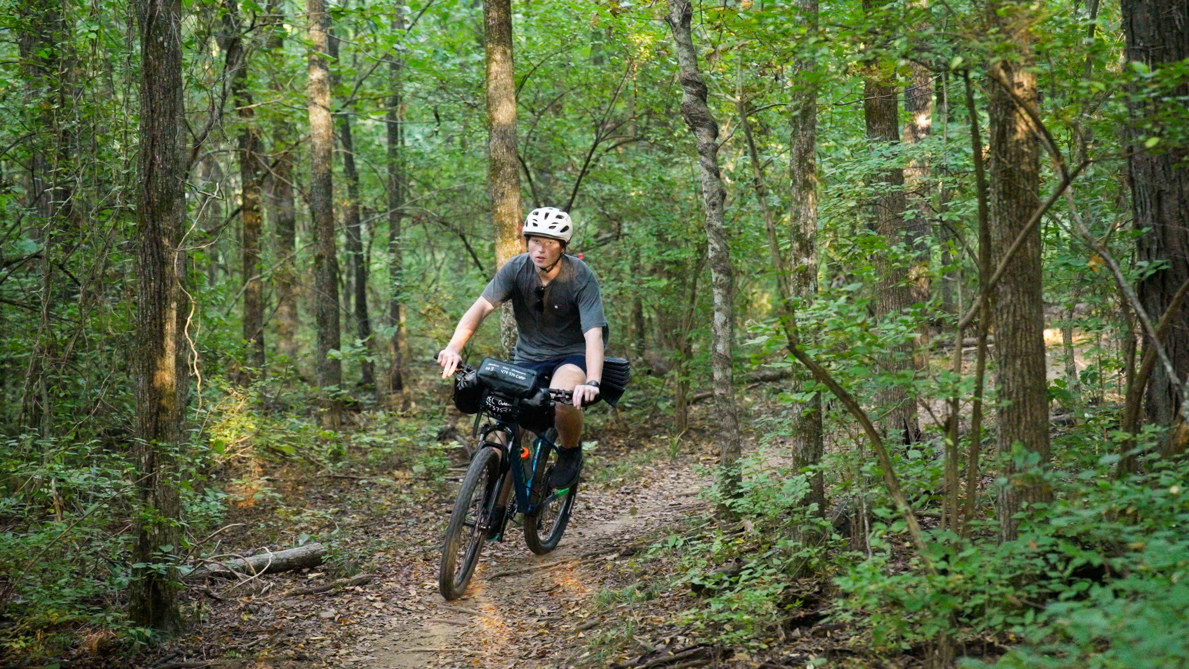 A bikepacking student rides their bike on the Fayetteville Traverse trail.
